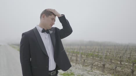 man in tuxedo in a vineyard