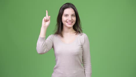 young happy beautiful woman pointing finger up