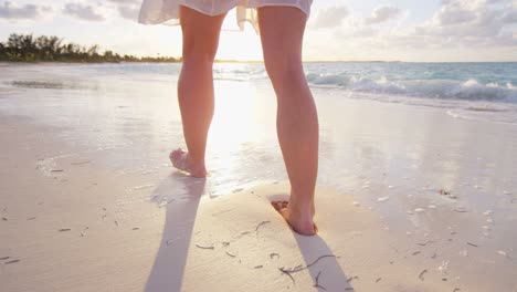 legs of female caucasian barefoot on ocean beach