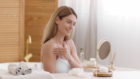 woman applying skincare cream in bathroom