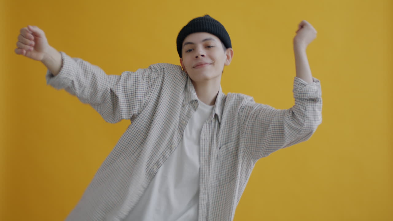 Young Person Dancing in Front of a Yellow Background