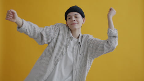 young person dancing in front of a yellow background