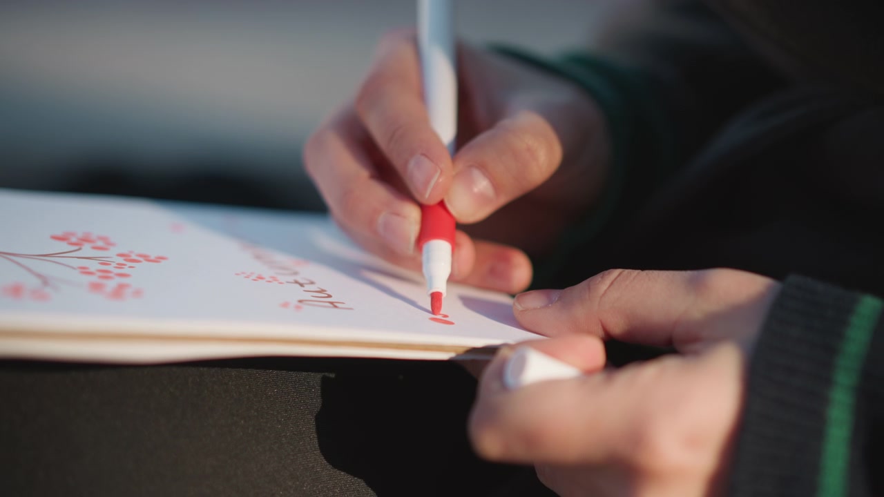 Person Drawing Red Berries on Paper with Marker