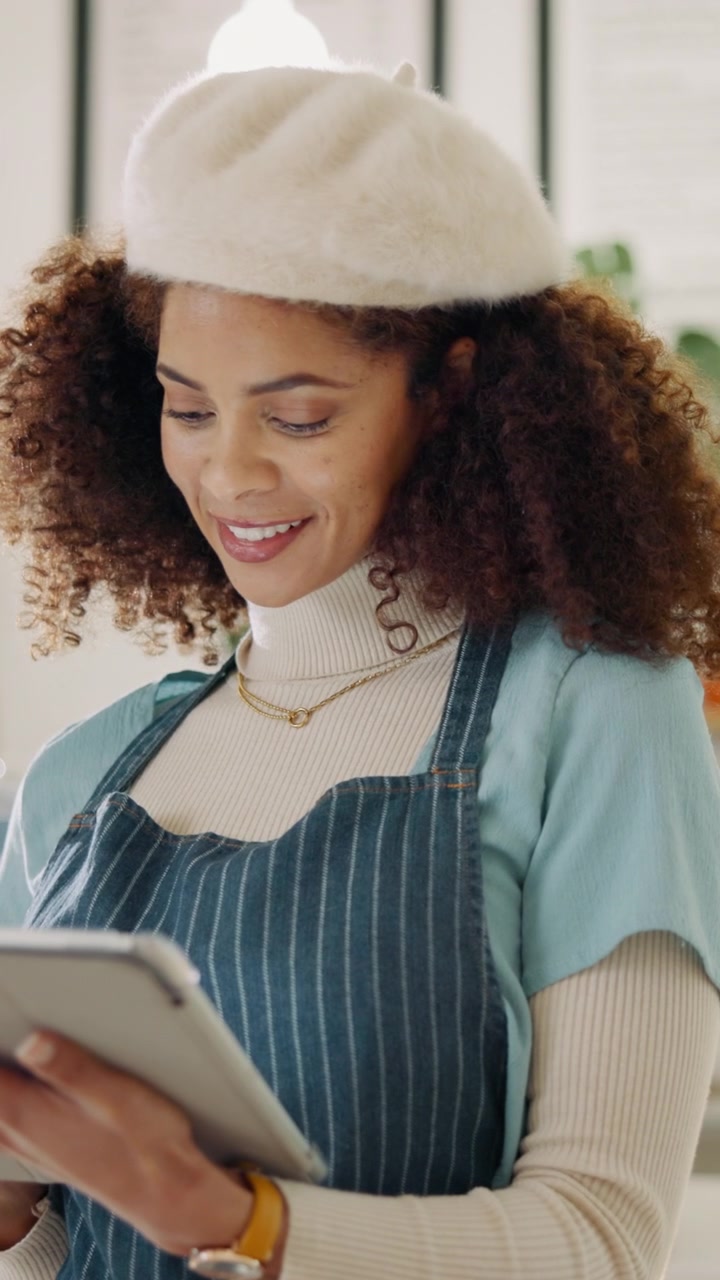 Smiling Woman Wearing Apron and Beret Using Digital Tablet