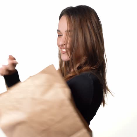 happy young woman holding a shopping bag on white background. let's go shopping concept. positive human emotions.