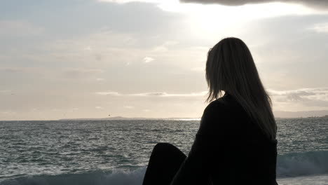 Mujer-Triste-Y-Rubia-Mirando-Al-Mar-Durante-La-Hora-Dorada