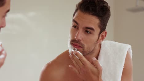 handsome man putting shaving foam on face