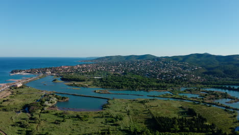 Villepey-pond-and-Saint-aygulf-city-aerial-shot-France-sunny-day