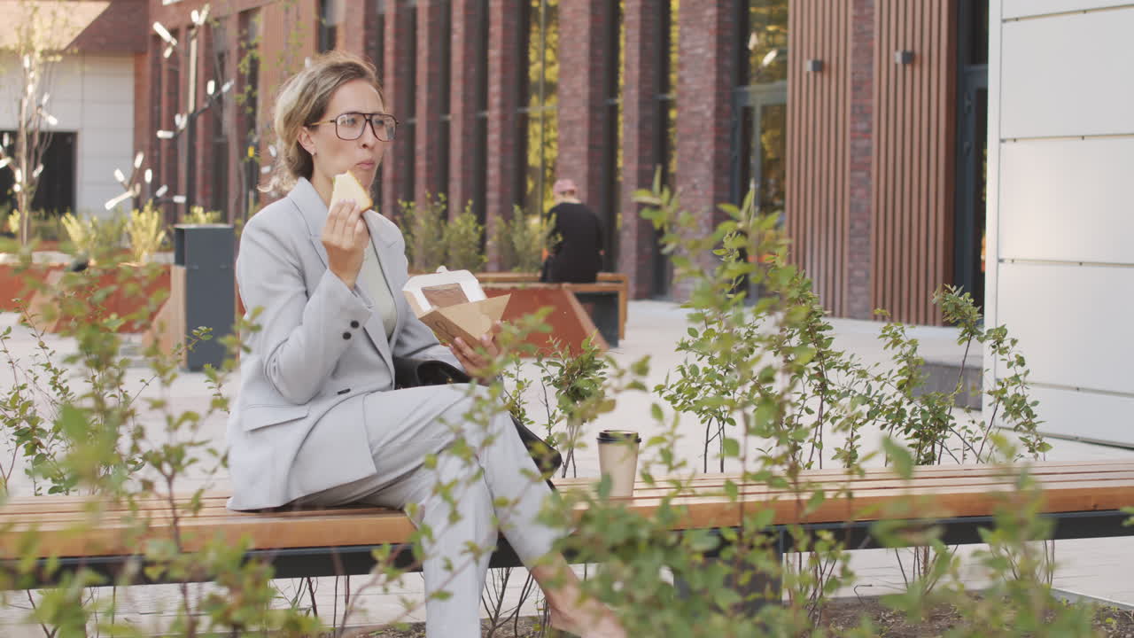 Businesswoman Eating Sandwich Outdoors