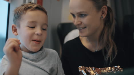 Kid-and-mother-passing-the-time-with-pad-during-train-journey