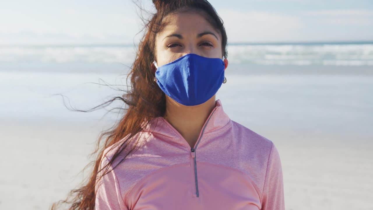 retrato de una mujer de raza mixta con máscara facial en la playa