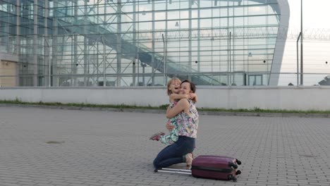 mother meet her daughter child near airport terminal with open arms after long flight trip work