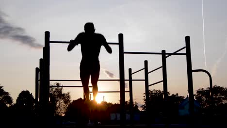 Junge-Männliche-Silhouette,-Die-Bei-Hellem-Sonnenaufgang-Muskel-Ups-Mit-Widerstandsband-übt