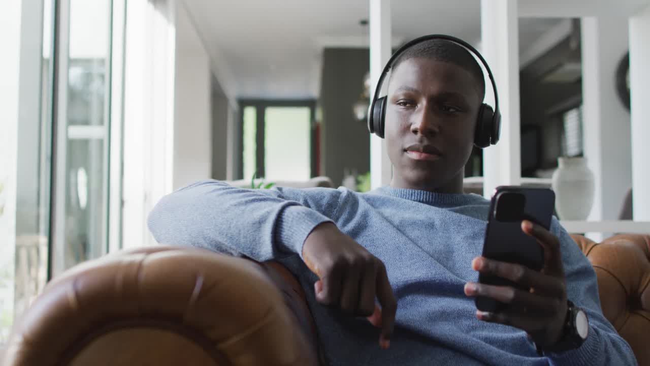 Video of african american man using headphones and listening to music