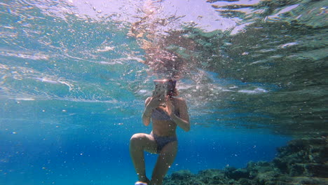 Una-Niña-Filma-Con-Su-Teléfono-Bajo-El-Agua-Con-Todo-El-Equipo-De-Buceo,-Grecia