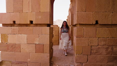 Woman-Walking-Through-Ancient-Structures-In-Petra,-Jordan---pullback