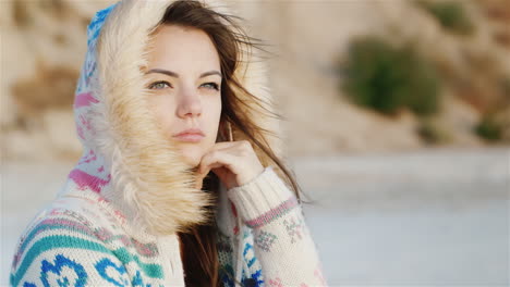 Thoughtful-Young-Woman-Sitting-On-The-Beach-The-Wind-Blowing-In-Her-Face-Cool-Day-Time-To-Dream