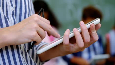 teacher standing holding digital tablet