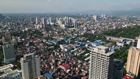 aerial drone shot of dense cityscape, urban sprawl, and commercial buildings during daytime at quezon city, philippines.