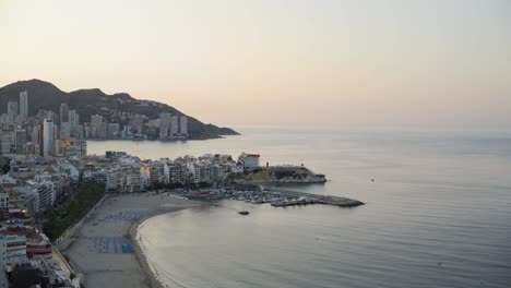 mediterranean dawn, wide view benidorm beach and coastline from above 4k