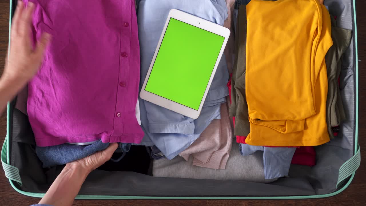 manos empacando maleta de viaje con cosas personales