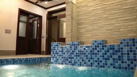 water flowing over jacuzzi into indoor swimming pool