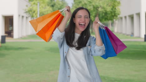chica india feliz bailando con bolsas de compras