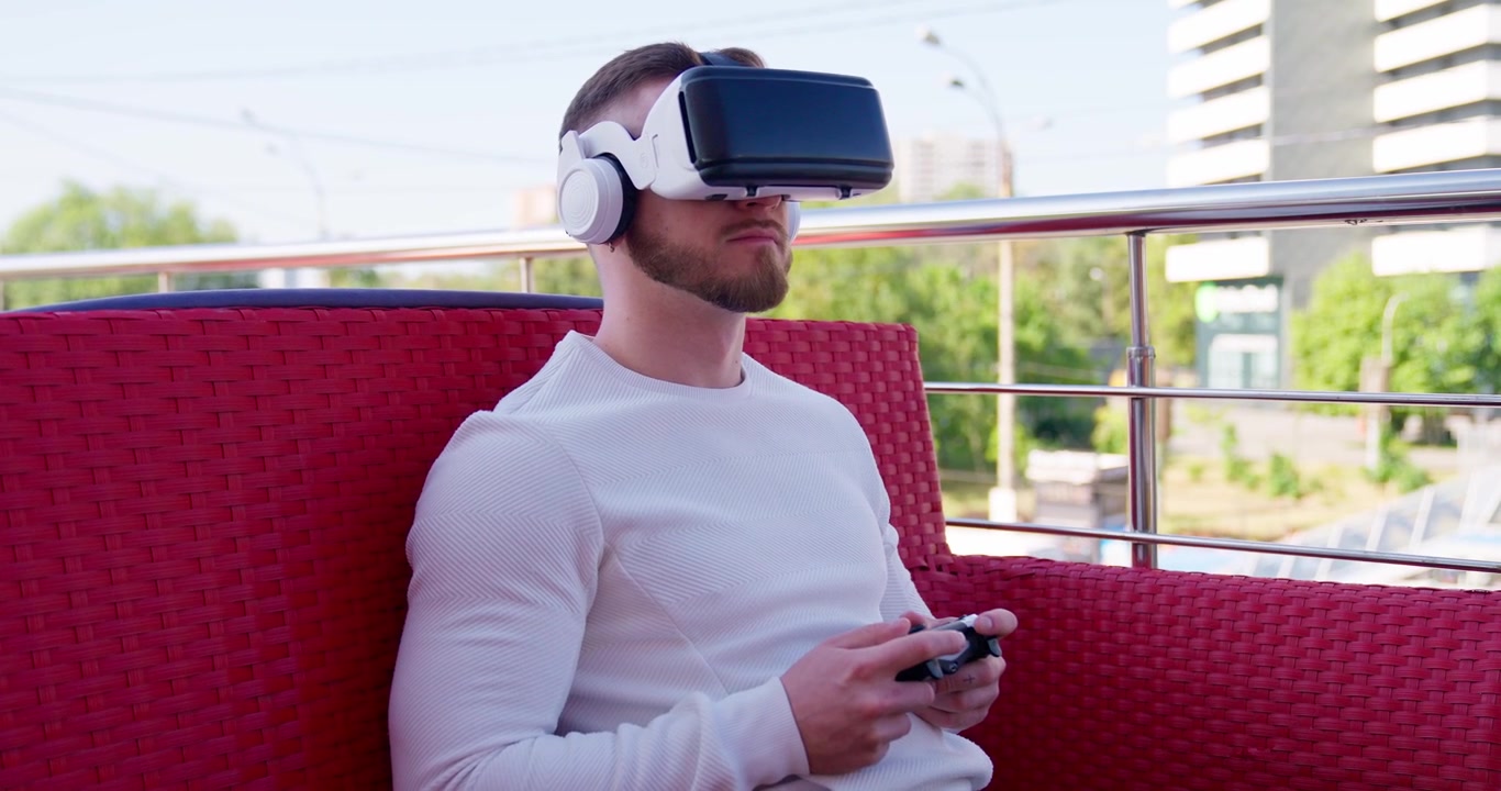 Giovane uomo che gioca a un videogioco in realtà virtuale con controller all'aperto