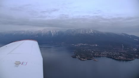 single engine airplane wing in flight, mountain coastline background