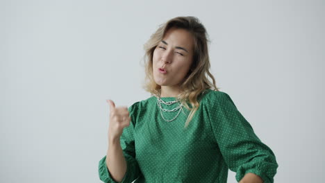 woman in green polka dot dress with a confident expression