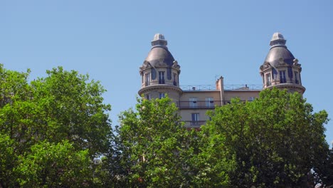 upper exterior architecture of a building behind trees in alboni street , paris, france