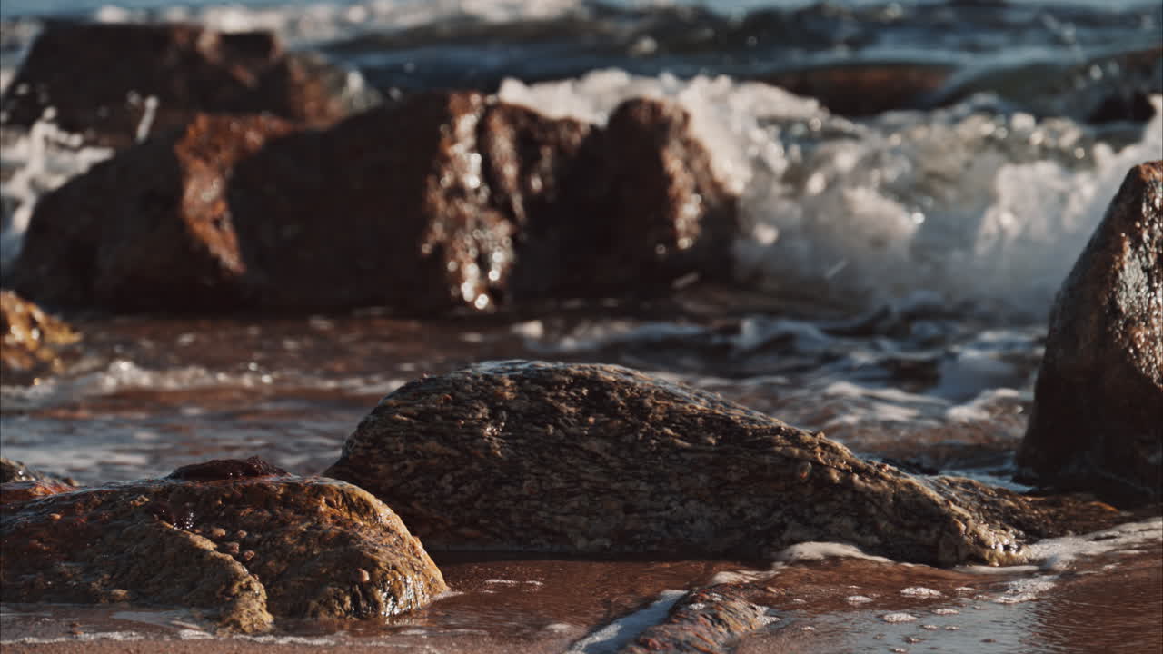 Primo piano di onde che si infrangono sugli scogli sulla spiaggia di Cannes, Francia