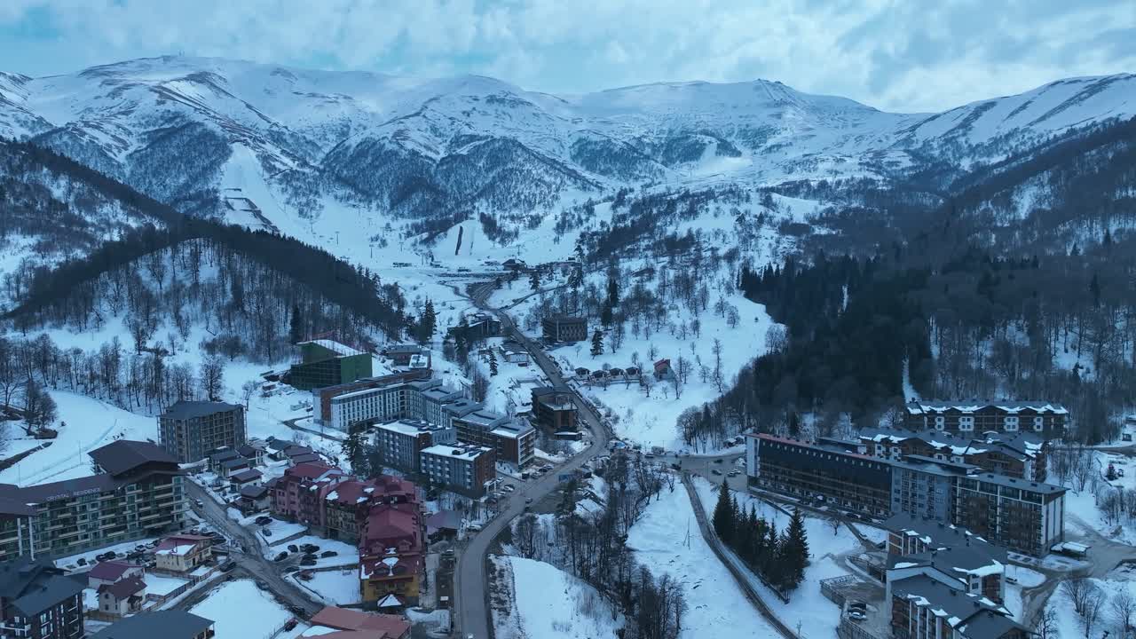 una hermosa vista aérea de una carretera que serpentea a través de un denso bosque con árboles cubiertos de nieve, capturando la belleza serena y tranquila de un paisaje de invierno