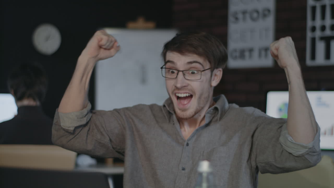 бизнесмен ищет ноутбук в темном офисе. счастливый человек празднует успех