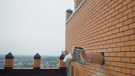 outer shiny steel ventilation pipes in brick wall of building