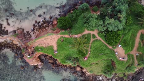 toma en órbita de arriba hacia abajo de turistas explorando la exquisita isla de las palomas mirissa, sri lanka