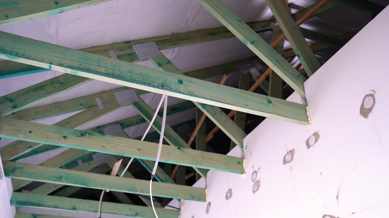 Impregnated roof trusses and exposed wiring in unfinished house under construction