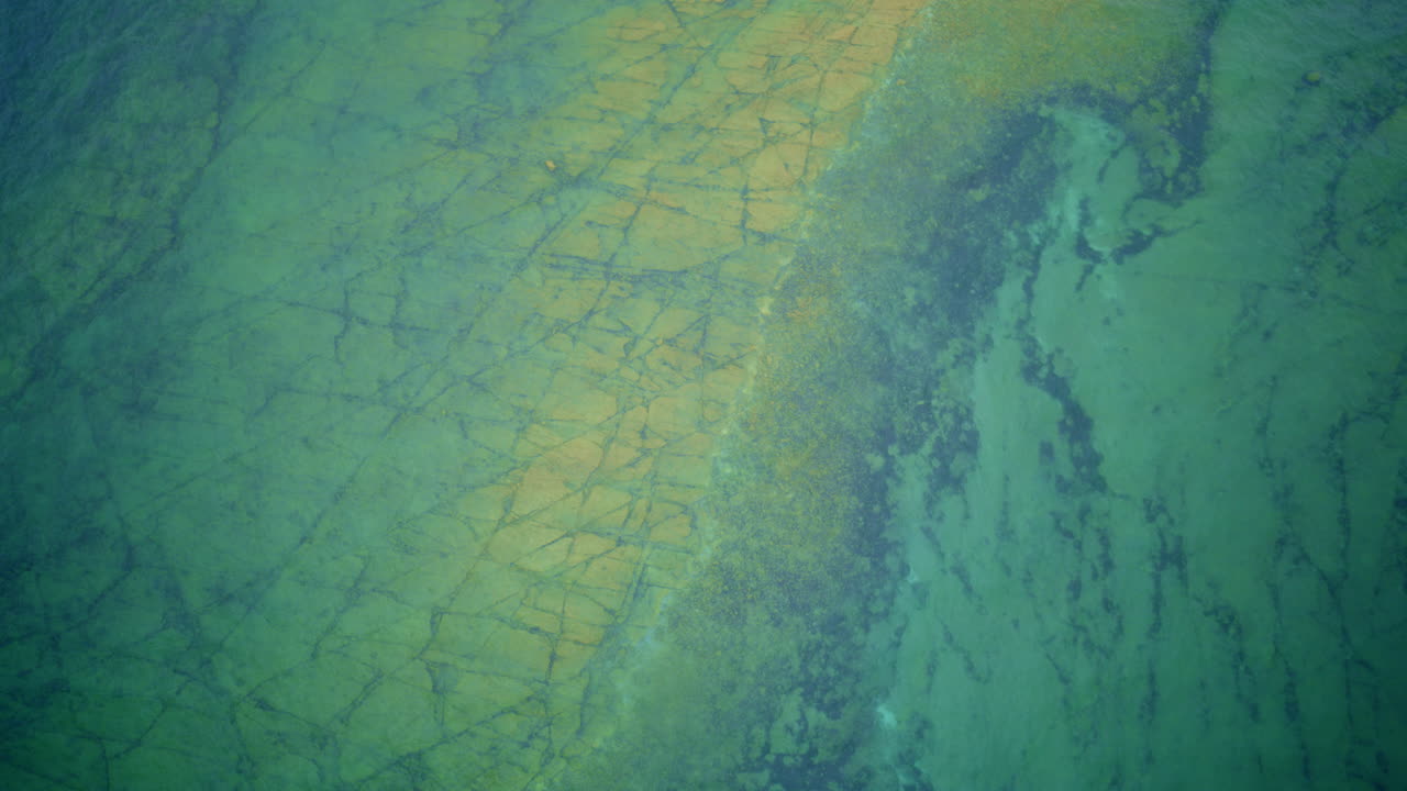 Drone shot looking down on lake Michigan and interesting rock formation