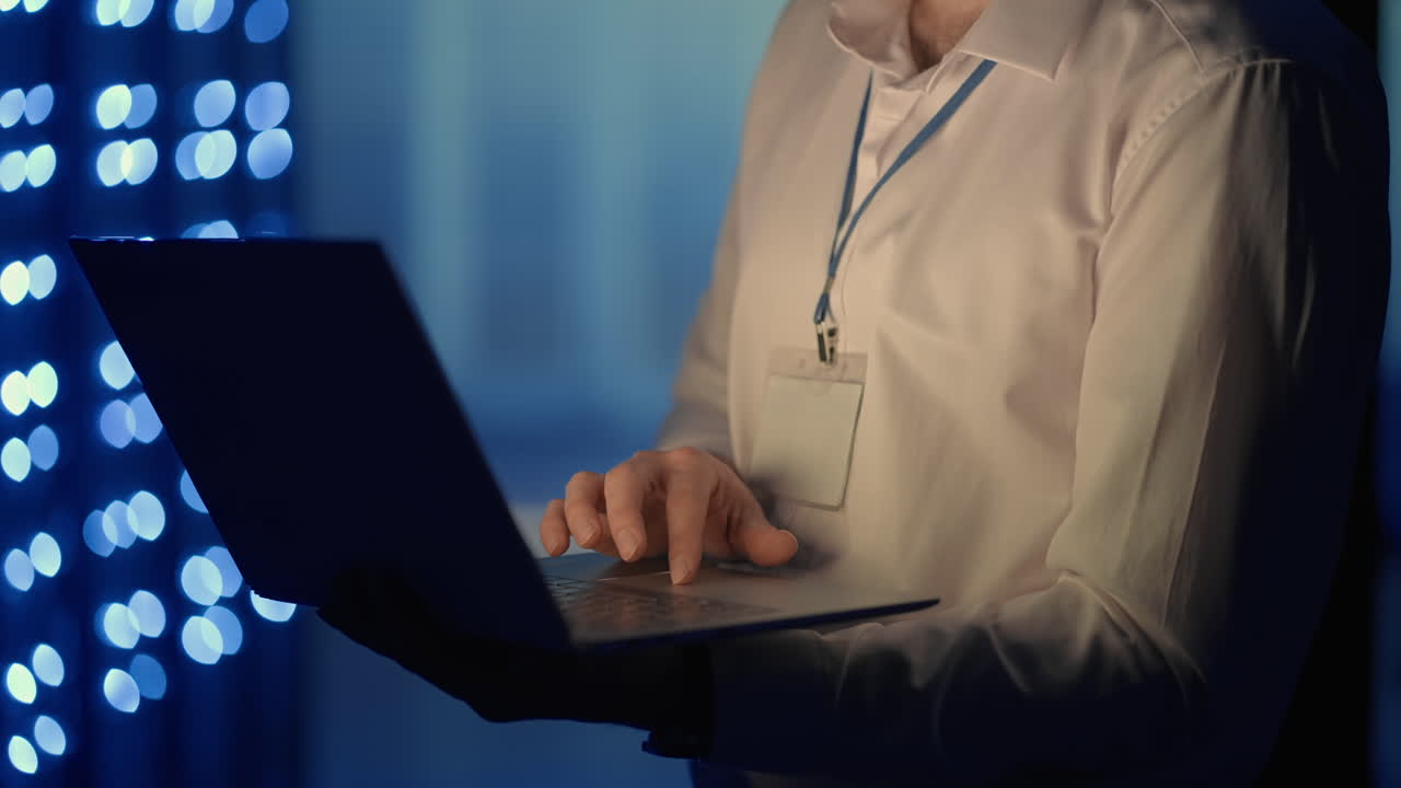 Face portrait of man working in server room with laptop. technician doing a checkup in the server room. Caucasian engineer wearing grey worker jacket