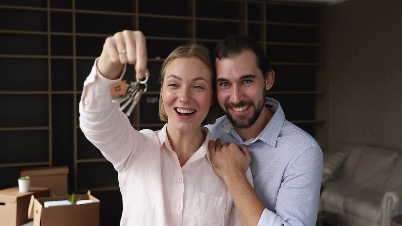una hermosa pareja mostrando las llaves de su nueva casa.