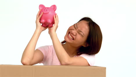 happy asian woman shaking piggy bank