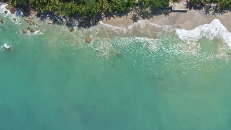Aerial-top-down-side-view-of-the-landscape-seaside-area-with-the-nice-view-of-the-turquoise-sea-water-from-the-Island-of-Puerto-Galera,-Philippines