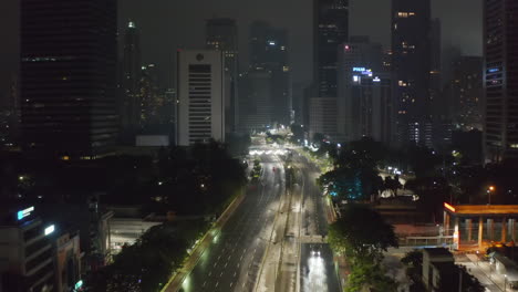 Aerial-dolly-forward-flying-shot-of-almost-empty-multi-lane-highway-at-night-during-covid-19-coronavirus-lockdown-pandemic-in-large-urban-city-center-in-Jakarta