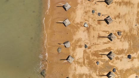 Toma-Aérea-De-Arriba-Hacia-Abajo-De-La-Barrera-Antiaterrizaje-En-La-Playa-De-Arena-De-Kinmen,-金門,-Isla-Quemoy,-Taiwán