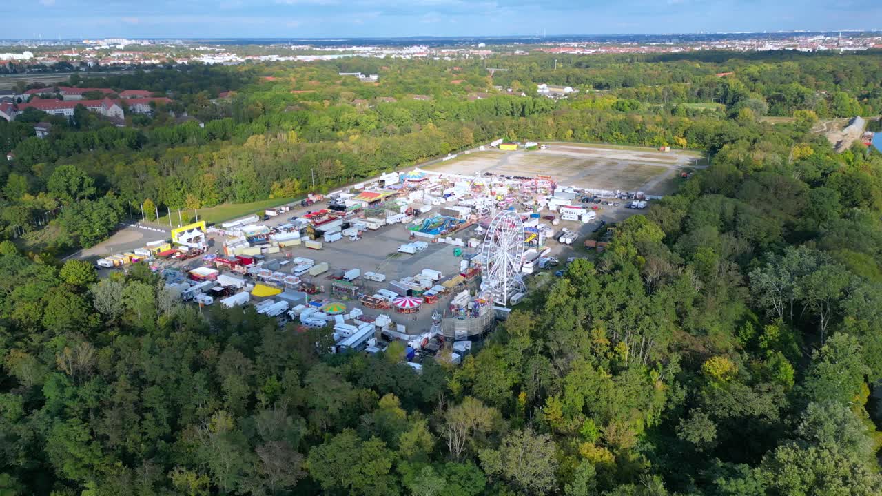 Berlin funfair showing a Ferris wheel, amusement rides, and various stalls from an aerial perspective. Fantastic aerial view flight fly push forward drone