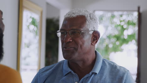 Senior-Father-Talking-And-Laughing-With-Adult-Son-Indoors-At-Home