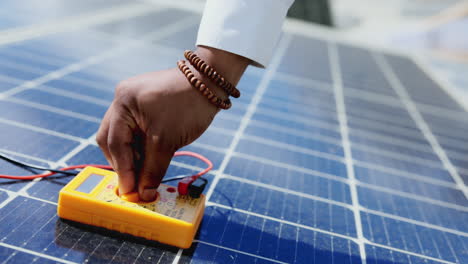 técnico, manos y multímetro de pruebas solares