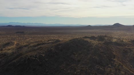 rugged mountain ridgeline overlooking the mojave desert basin - sliding aerial view