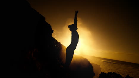 woman silhouetted against a stunning sunset ocean sunrise