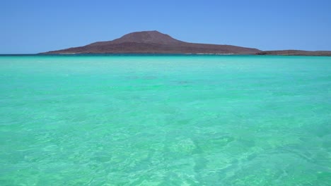 Beautiful-turquoise-water-crystal-clear-with-volcano-in-the-background,-Isla-Coronado,-Loreto,-BCS,-Mexico